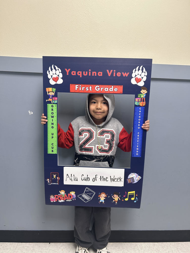 Smiling boy holding Atta Cub Kid of the Week picture frame