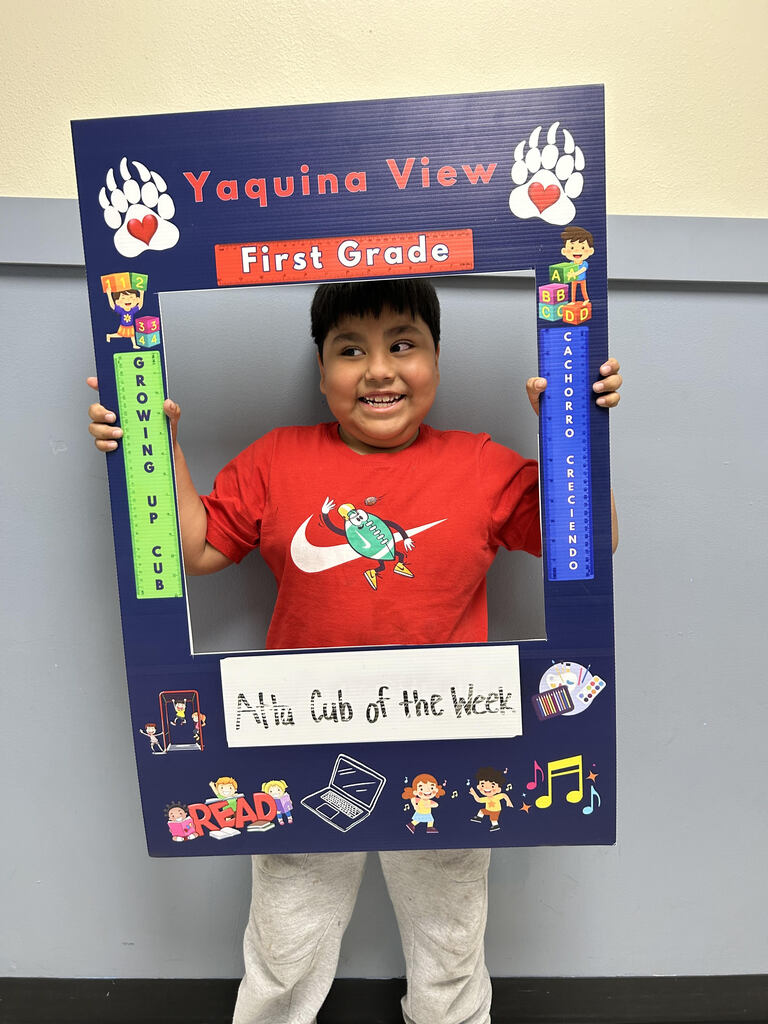 Smiling boy holding Atta Cub Kid of the week picture frame.
