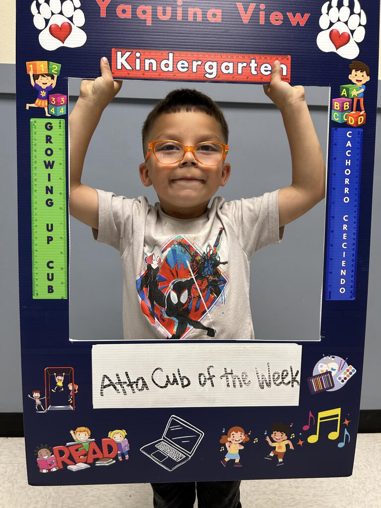Smiling boy holding Atta Cub Kid of the week picture frame.