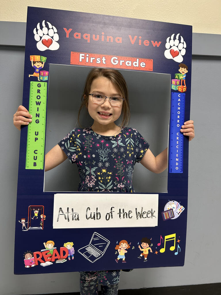 Smiling girl holding Atta Cub Kid of the week picture frame.