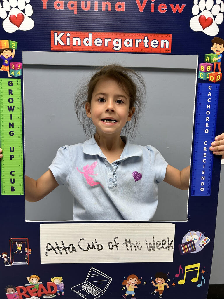 Smiling girl holding Atta Cub Kid of the week picture frame.