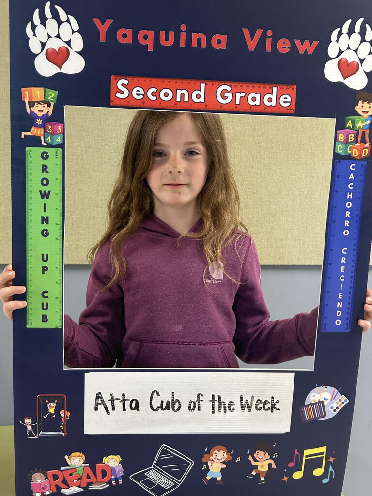 Smiling girl holding Atta Cub Kid of the week picture frame.