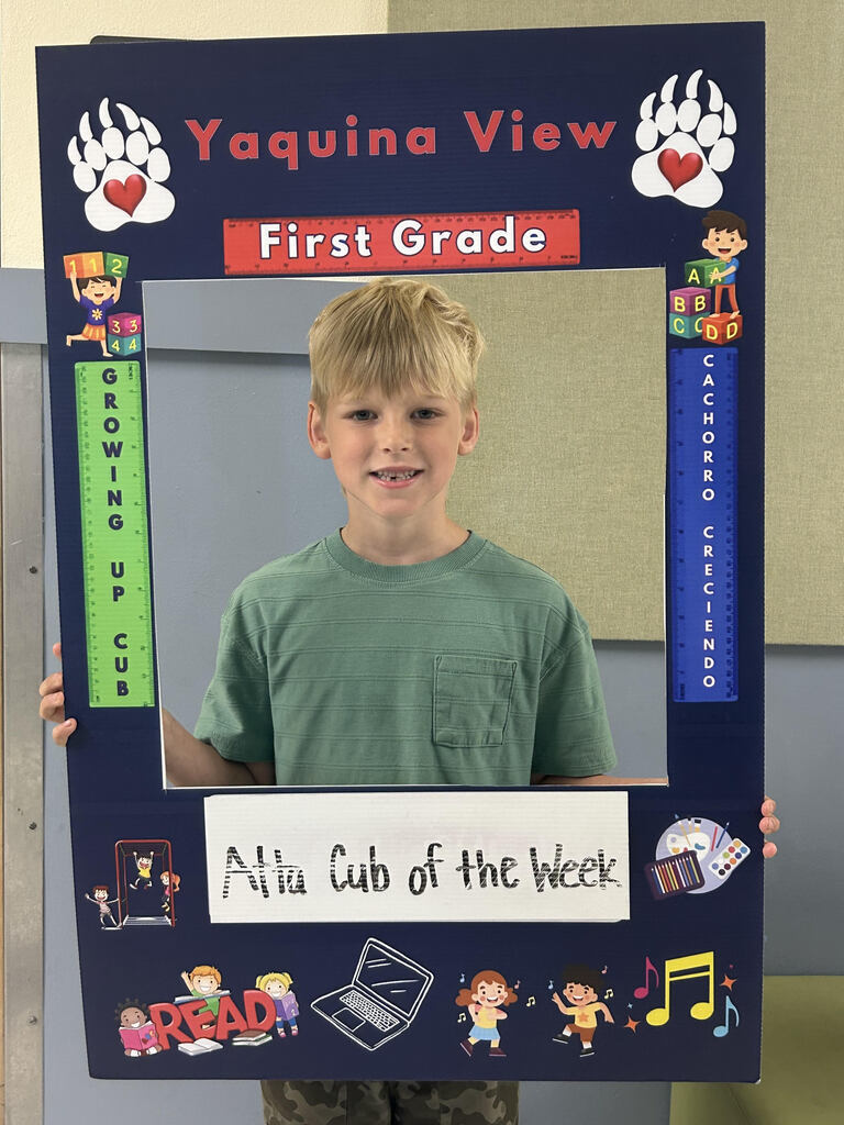 Smiling boy holding Atta Cub Kid of the week picture frame.