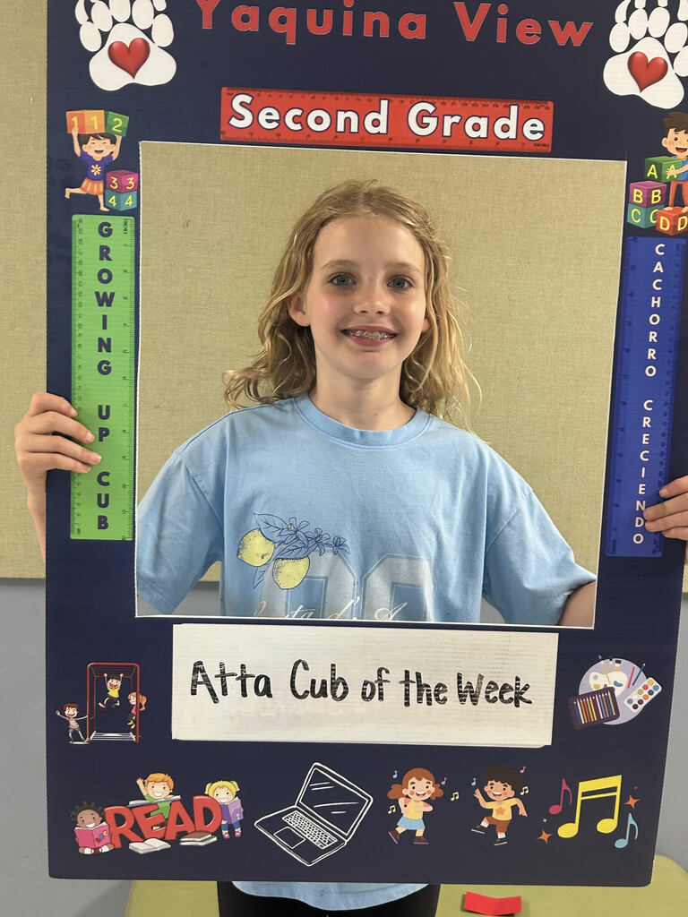 Smiling girl holding Atta Cub Kid of the week picture frame.