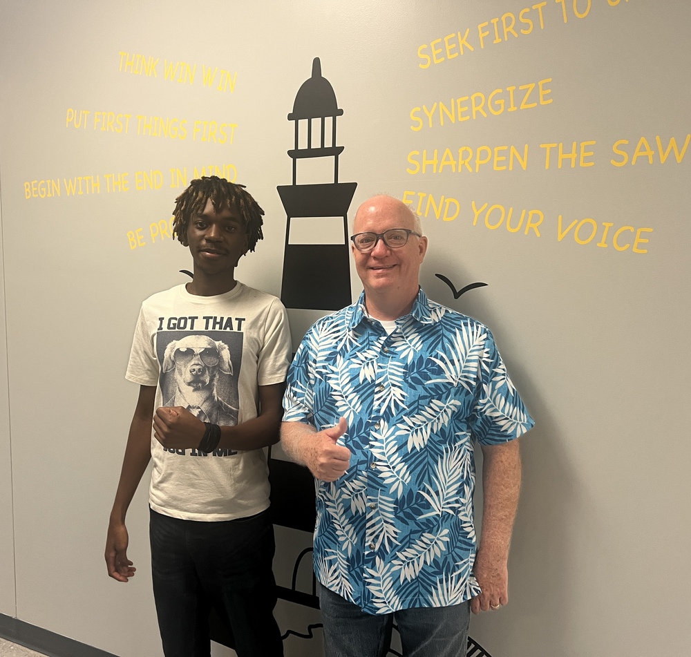 Dr. Beam posing in front of a lighthouse with a student leader.