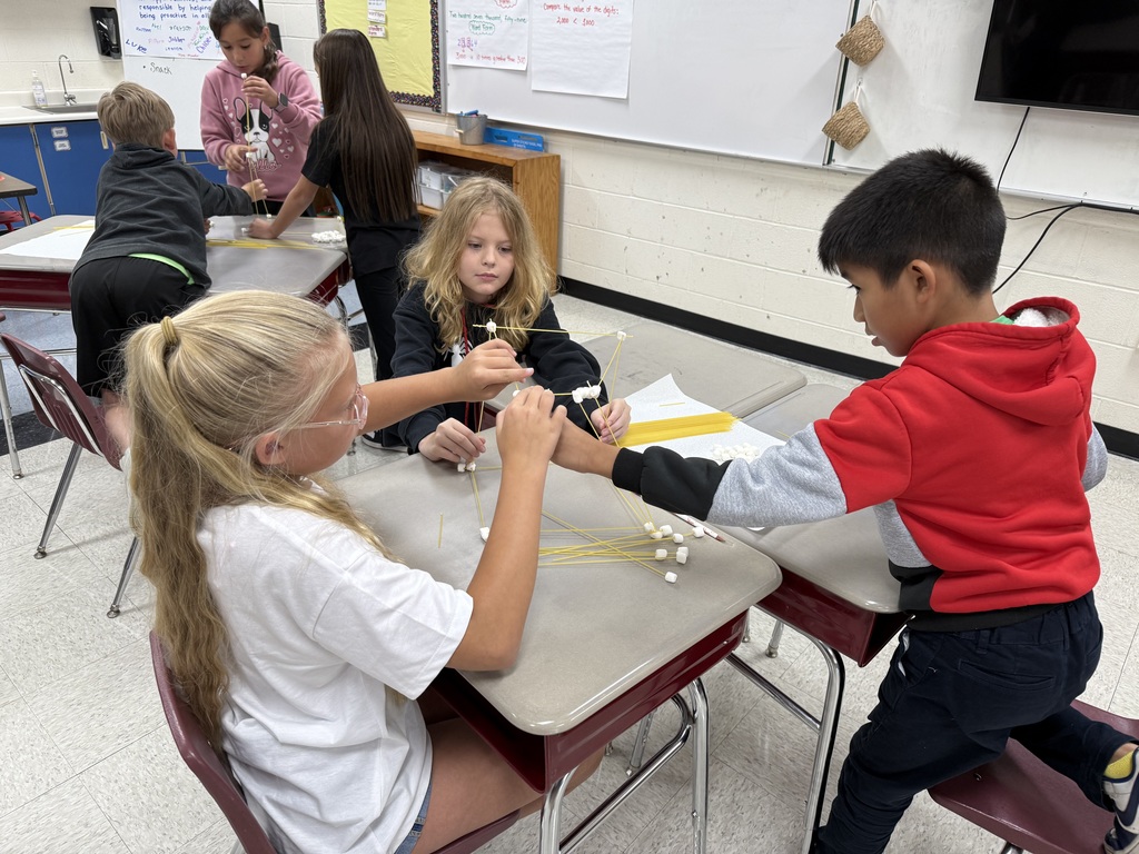 Students work on building structures with marshmallows and spaghetti.