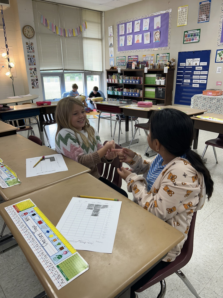 Students play rock, paper, scissors to make bar graphs.