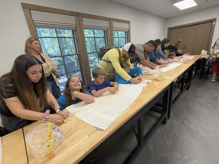 Students make corn husk dolls.