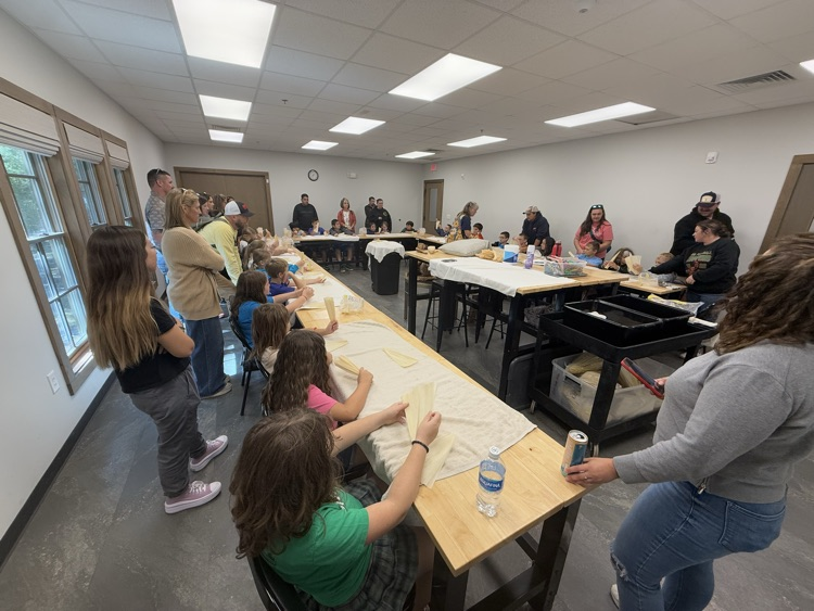 Students make corn husk dolls.