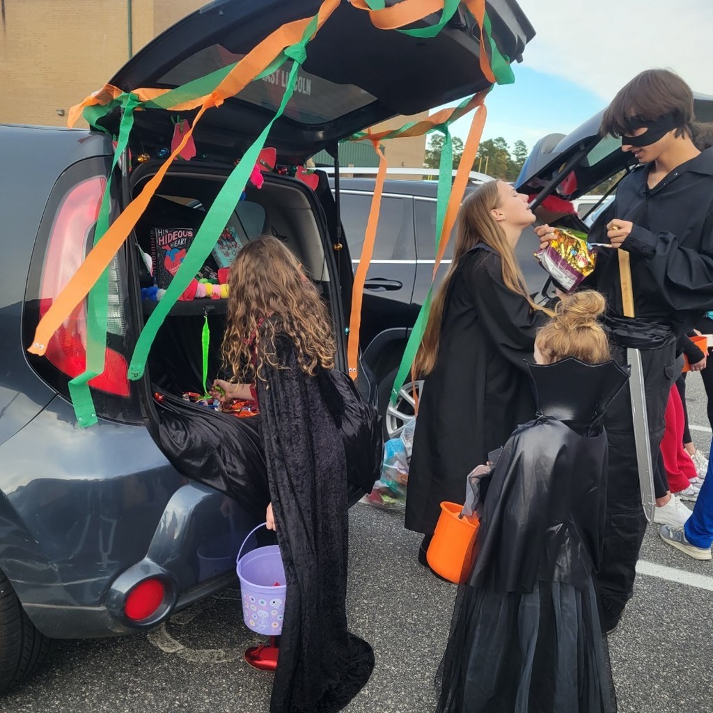 Two witches gathering candy from a trunk