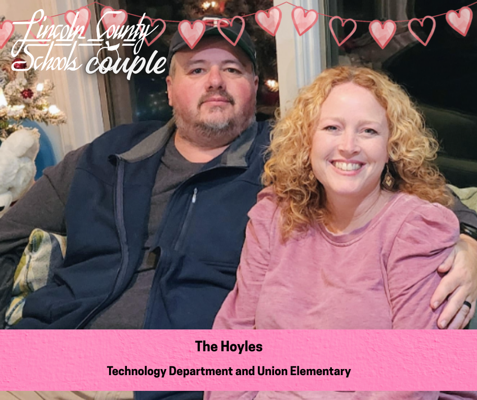A couple sits closely together on a couch indoors, smiling at the camera. The person on the left wears a dark jacket and a baseball cap, and the person on the right has curly red hair and wears a pink long-sleeve top. A decorated Christmas tree and window are visible behind them. Heart graphics and the text “Lincoln County Schools couple” appear across the top. A pink banner at the bottom reads “The Hoyles” and “Technology Department and Union Elementary.”