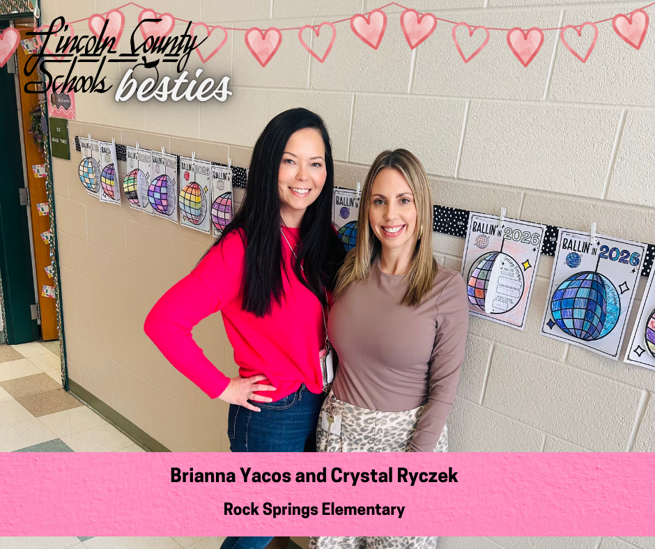 Two Rock Springs Elementary educators, Brianna Yacos and Crystal Ryczek, stand smiling side by side in a school hallway decorated with student artwork. A banner of pink hearts hangs above them, and colorful “Ballin’ in 2026” student drawings are clipped along the wall behind them. A pink caption bar at the bottom reads their names and school.