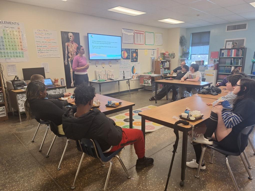 Students engaging in classroom discussion with guest speaker about personality tests.