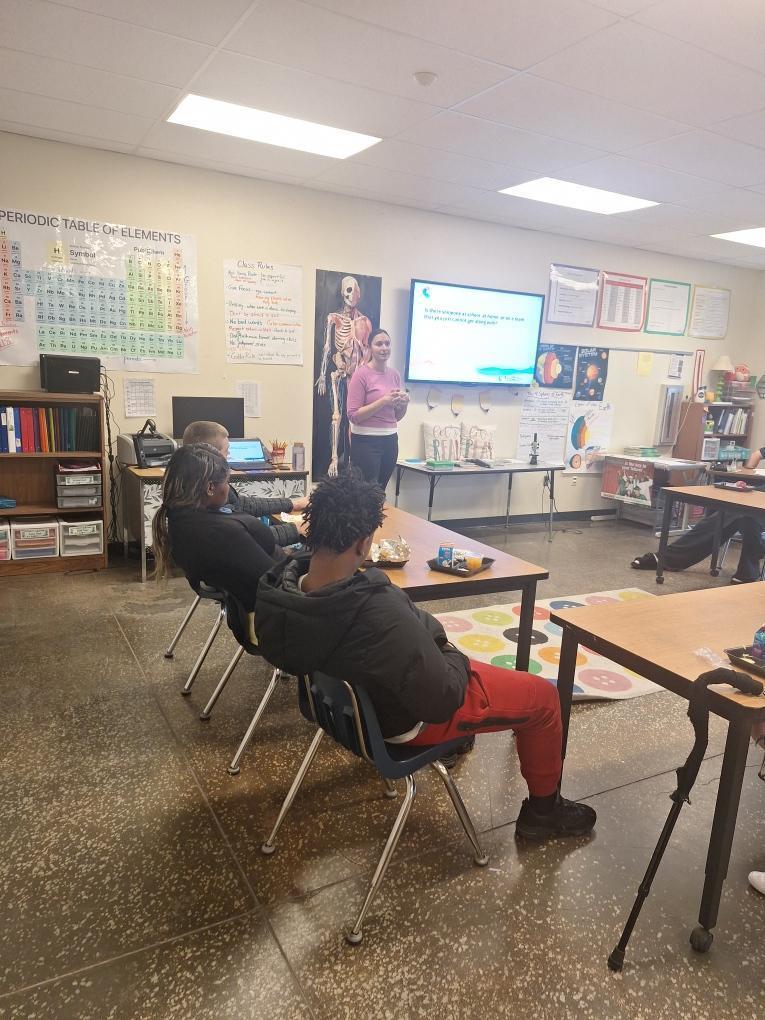 Students engaging in classroom discussion with guest speaker about personality tests.