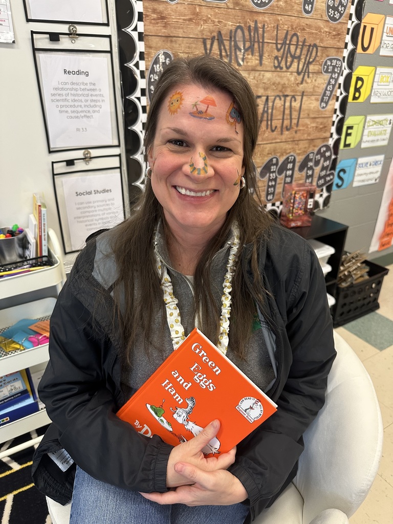 Staff member proudly display colorful temporary tattoos on their face during the 'Tattoo the Teacher' fundraiser.