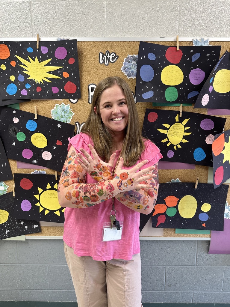 Staff member proudly display colorful temporary tattoos on their arms during the 'Tattoo the Teacher' fundraiser.