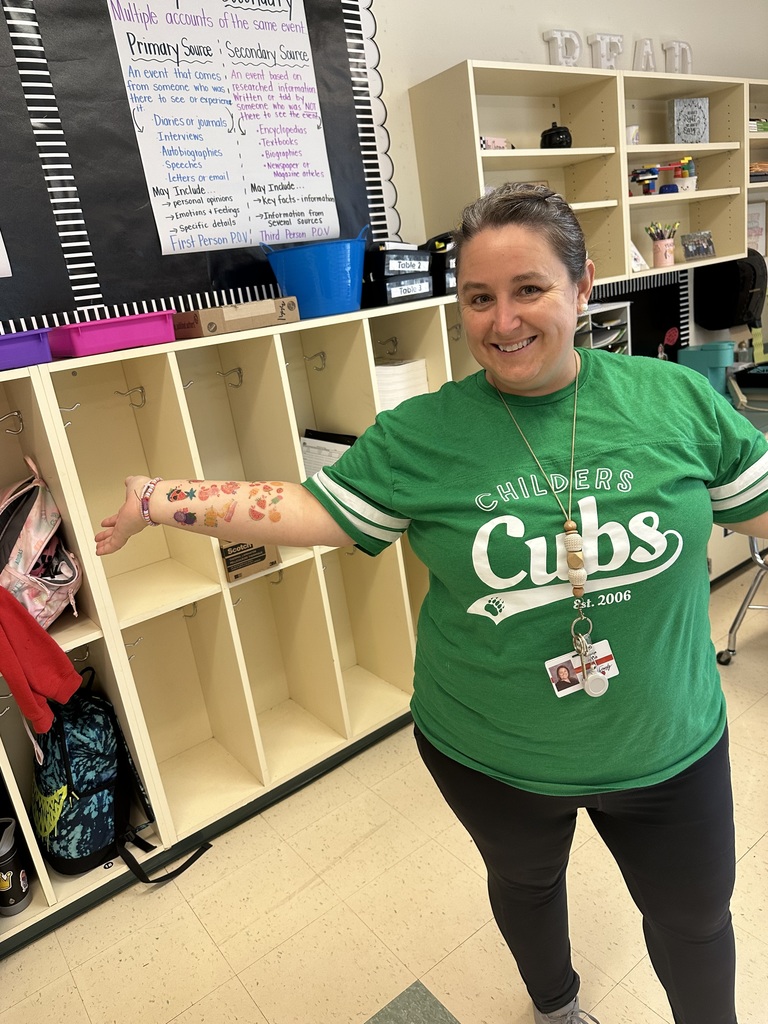 Staff member proudly display colorful temporary tattoos on their arms during the 'Tattoo the Teacher' fundraiser.