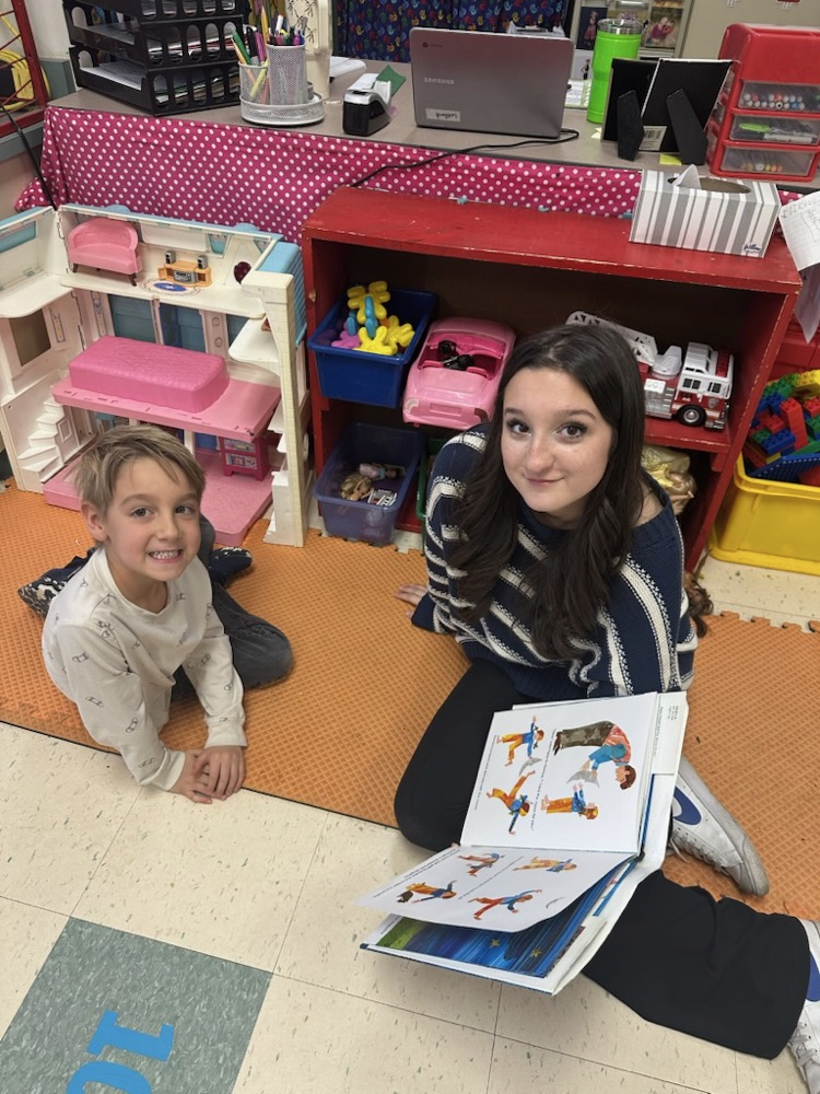 Middle School Student reading with a NCES student.