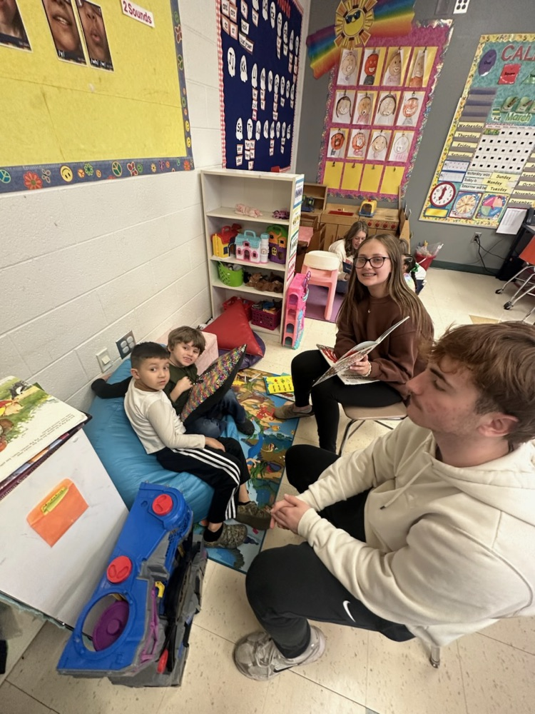 Middle School Students reading with NCES students.