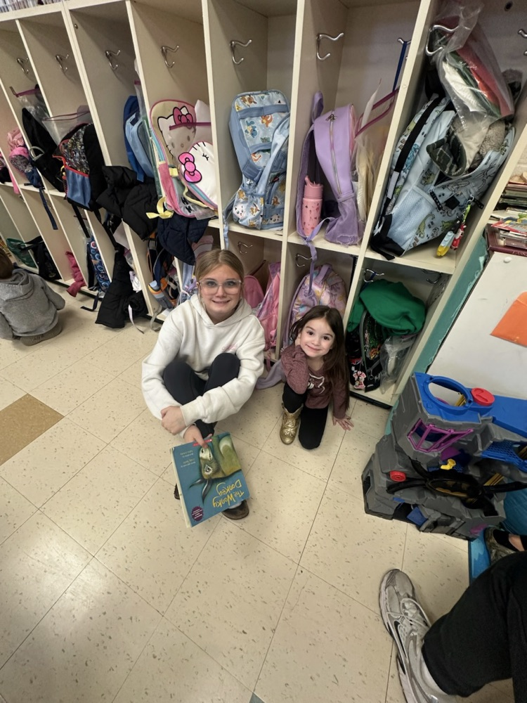Middle School Student reading with a NCES student.