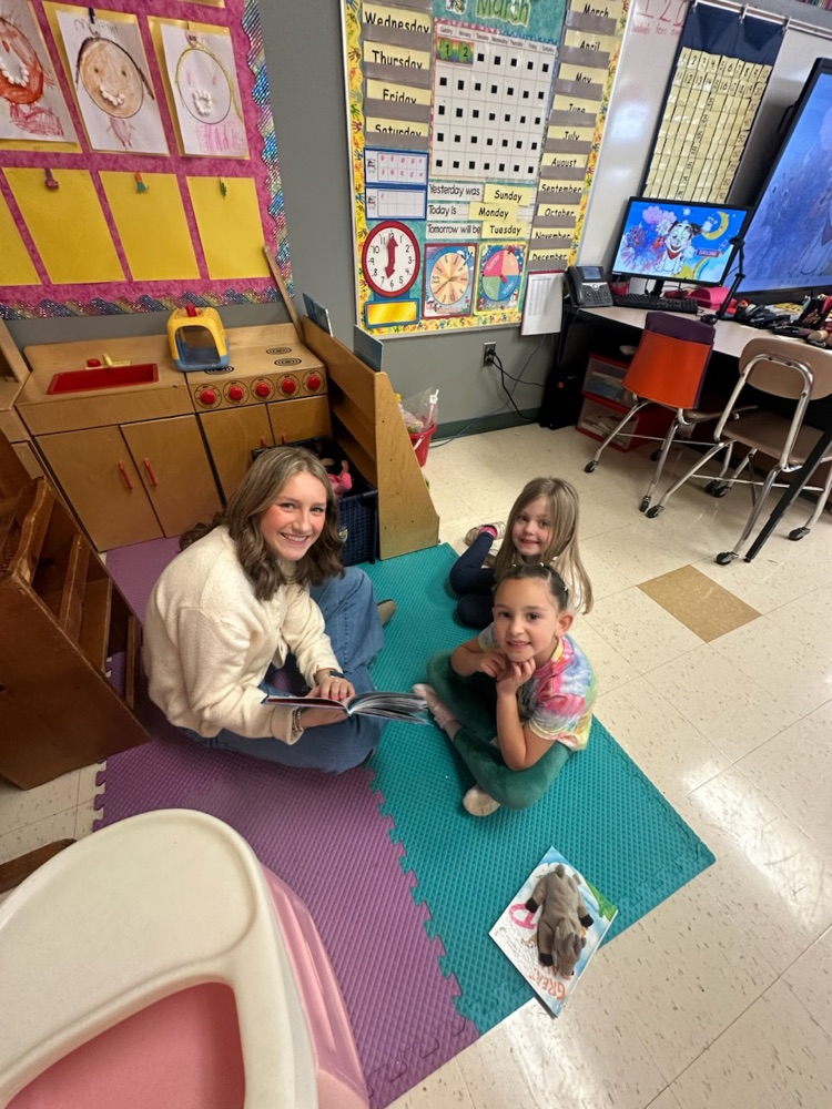 Middle School Student reading with a NCES student.