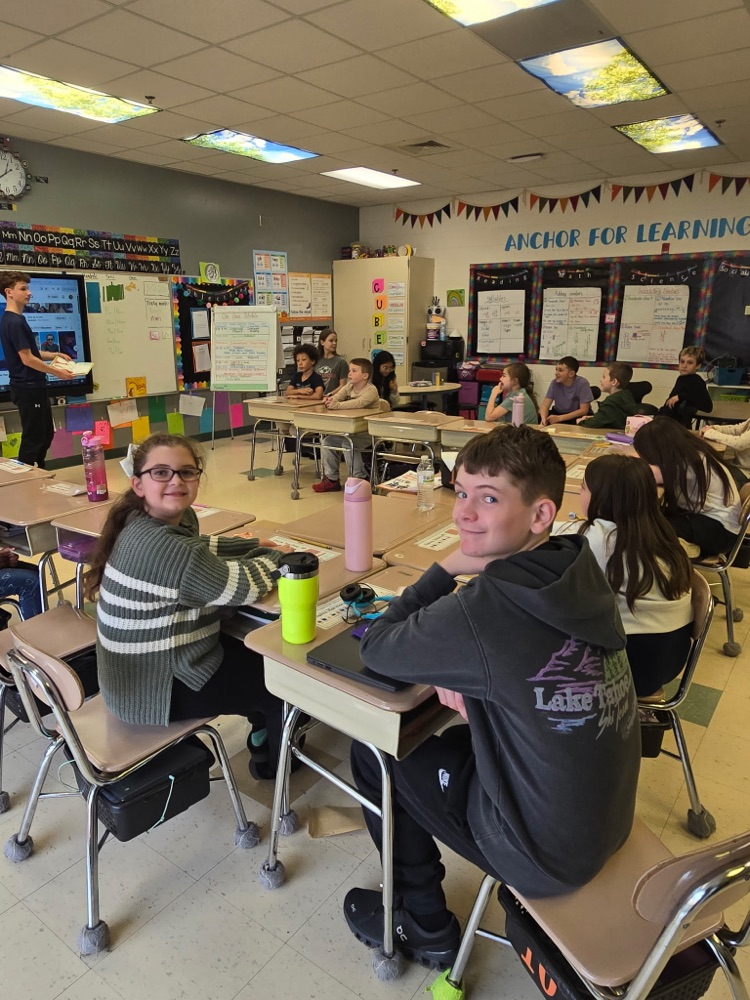 Middle School Student reading with a NCES student.