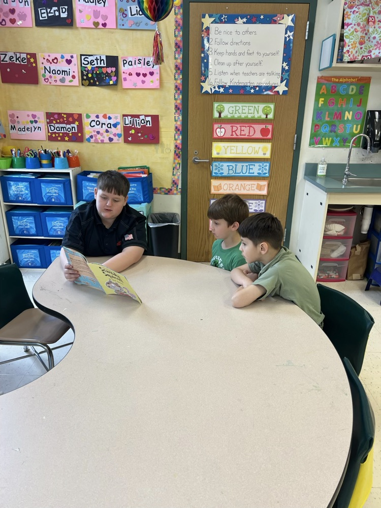 Middle School Student reading with a NCES student.