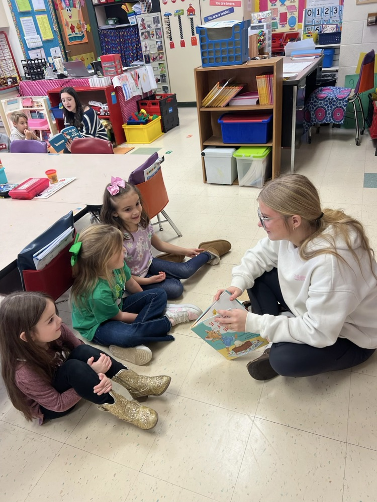 Middle School Student reading with NCES students.