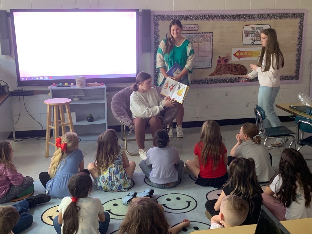 High School students and teachers reading to elementary students to celebrate Dr. Seuss Week.