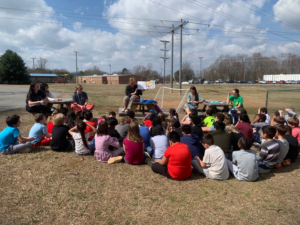 High School students and teachers reading to elementary students to celebrate Dr. Seuss Week.
