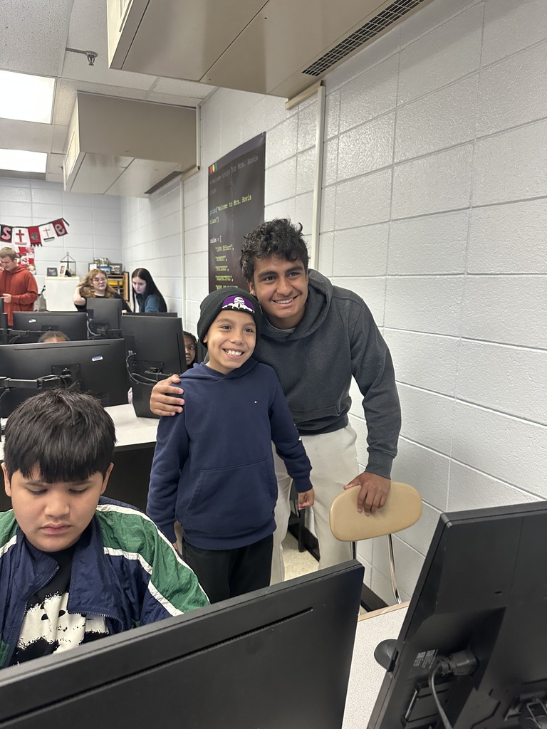 3rd grade students at the computers learning about coding from high school students.