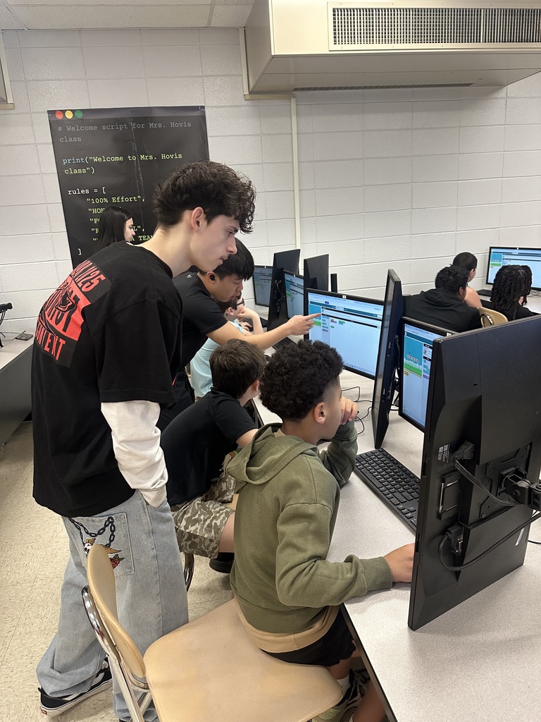 3rd grade students at the computers learning about coding from high school students.