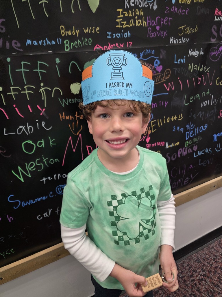 Student Carter holding a certificate for passing 5th grade sight words and student Marley holding a certificate for passing 2nd grade sight words. Both students are smiling and standing in a classroom setting.