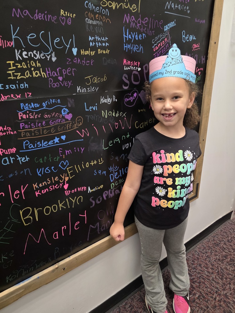 Student Carter holding a certificate for passing 5th grade sight words and student Marley holding a certificate for passing 2nd grade sight words. Both students are smiling and standing in a classroom setting.