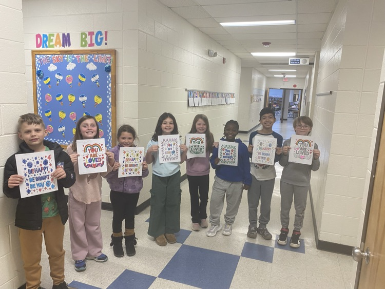Students lined the hallway proudly holding up their positive coloring sheets, each one featuring a different encouraging message. It was a simple, powerful visual of students lifting one another up to start the day.