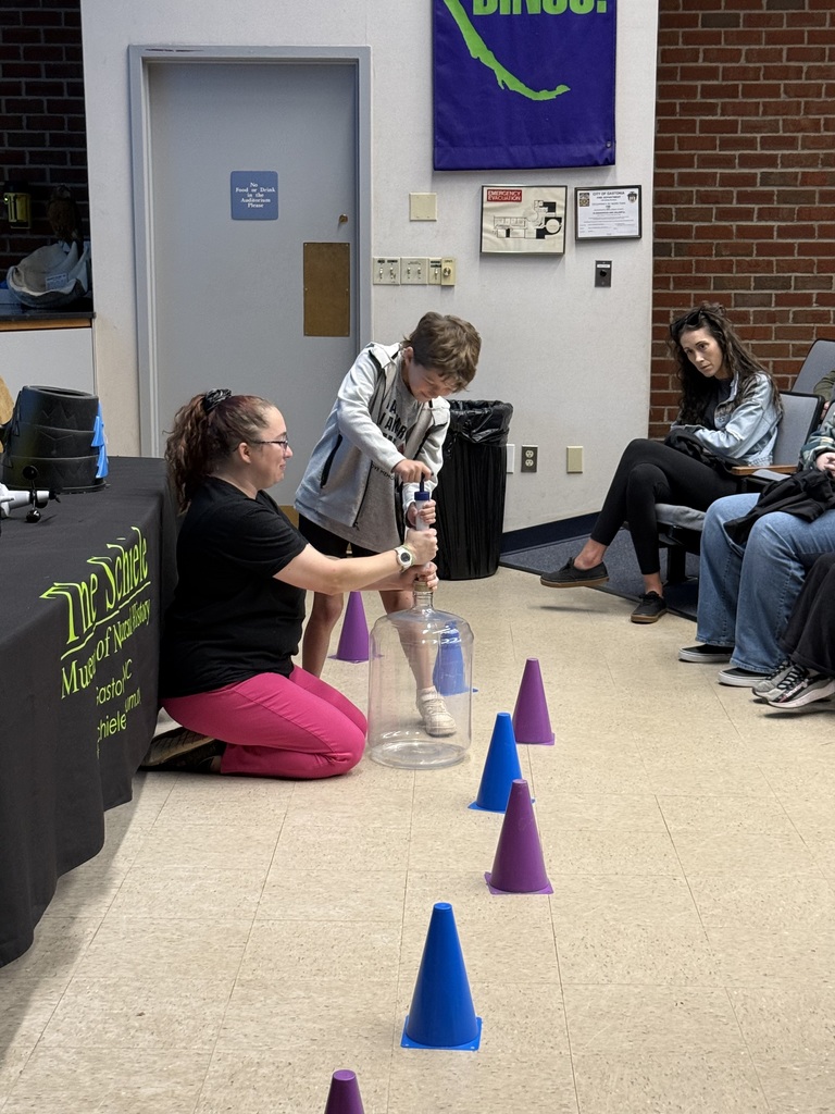 student preforming an experiment with a scientist while on a field trip