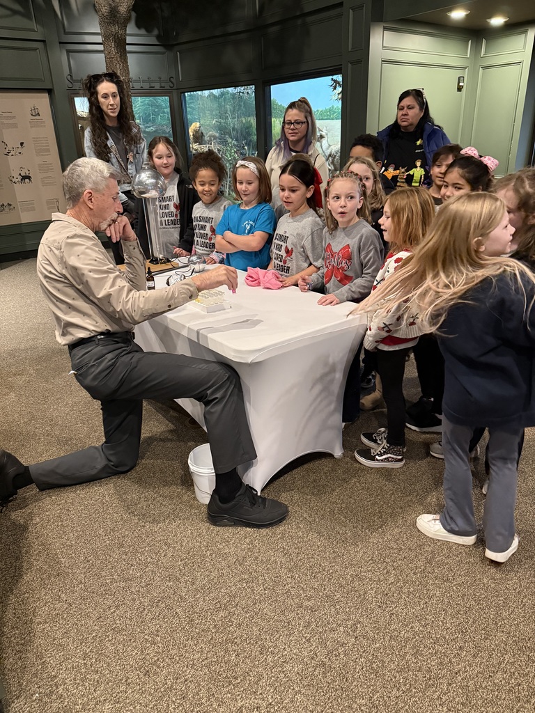 students crowded around table to view experiment