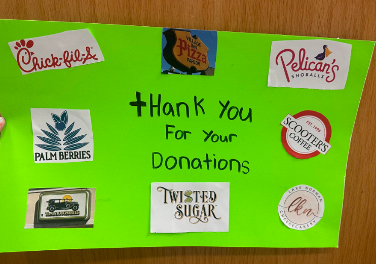 Handwritten sign on neon green poster board that reads: Thank You For Your Donations. The poster features logos from the following sponsors: Chick-fil-A, Village Inn Pizza Parlor, Pelican's Snoballs, Palm Berries, Scooter's Coffee Est. 1998, The Untouchables, Twisted Sugar, and Lake Norman LKN Cheesecakery.