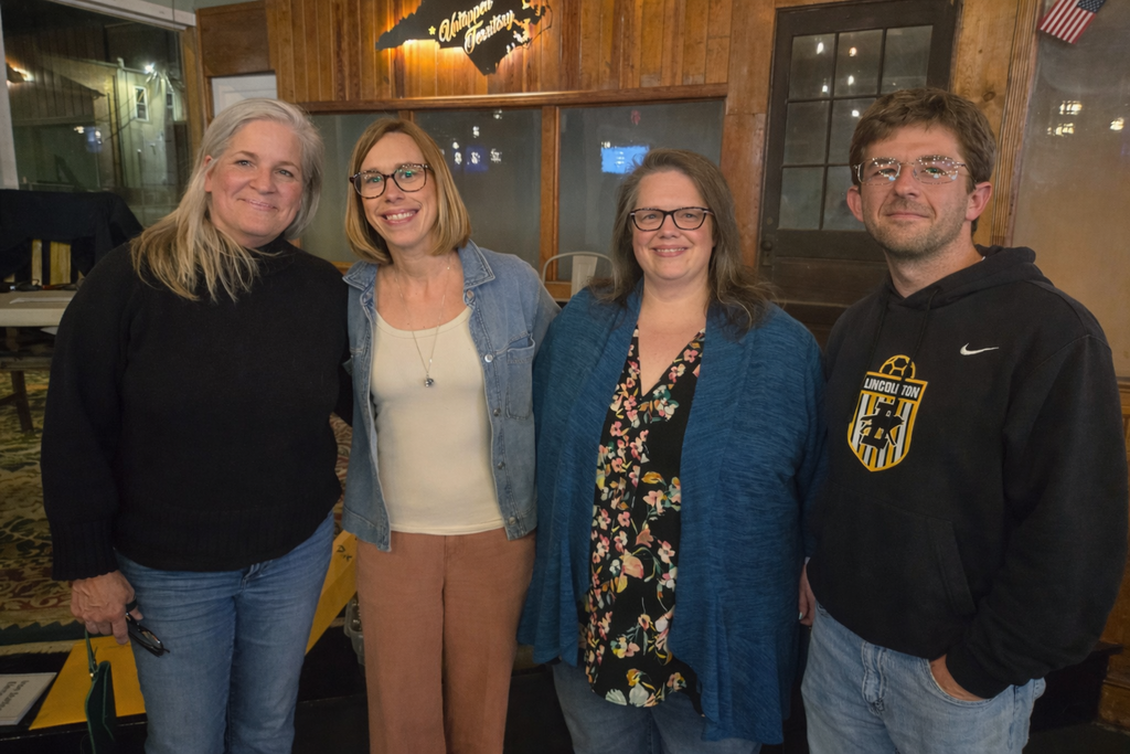 A large, colorful sign on an easel reads “Welcome to Battle of the Brains Trivia Night,” featuring the Lincoln County Chamber of Commerce logo, presenting sponsors Lincoln County Schools and Timken, and a list of additional sponsors below.