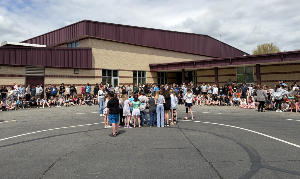 Whole school photo with students sitting to watch the March Madness winners