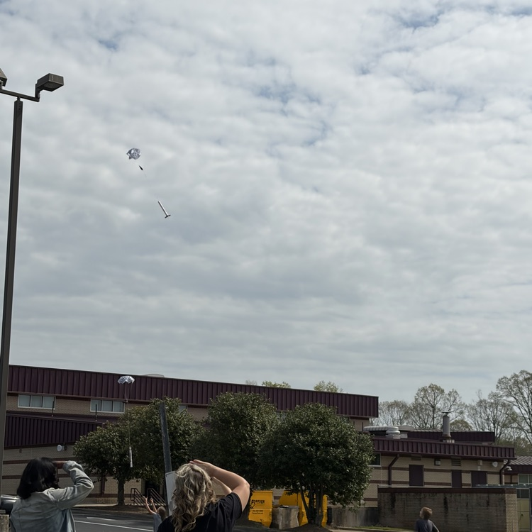 student and parents standing in the field for 5th grade rocket launch with star base