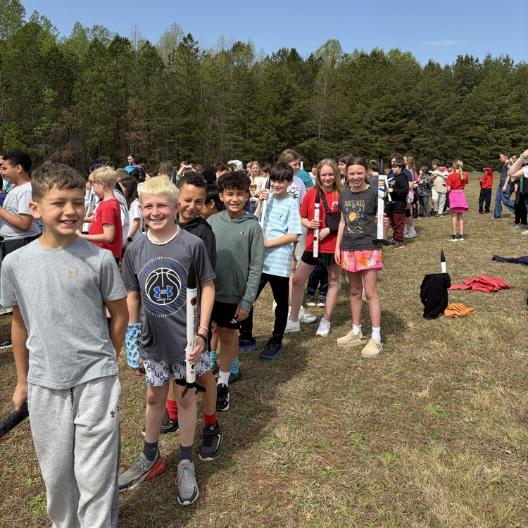student and parents standing in the field for 5th grade rocket launch with star base