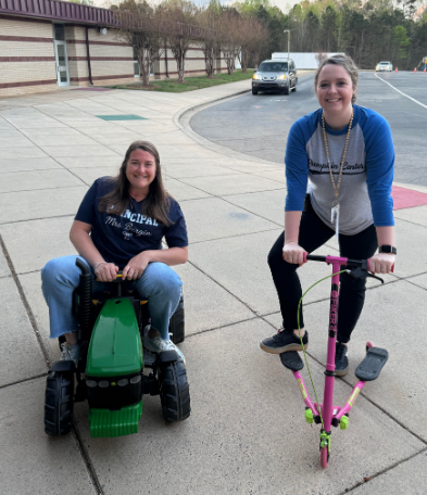 Principal Mrs. Burgin and Assistant principal Mrs. Webb on scooters and a tractor