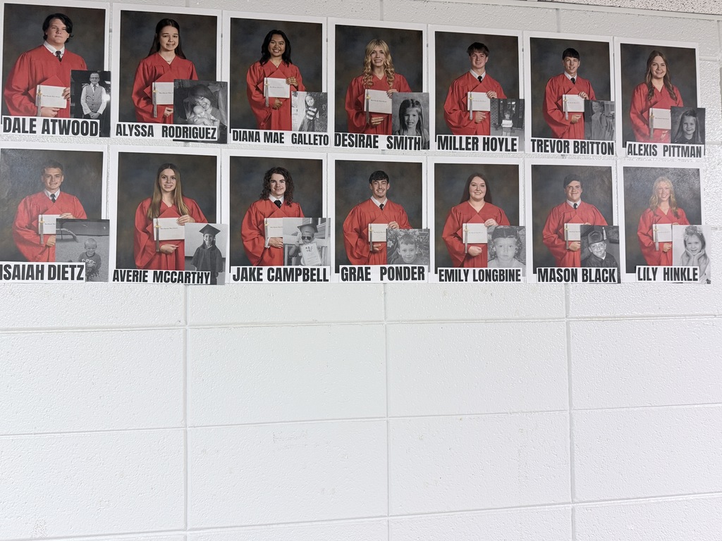 A series of photos on a white wall shows individuals in red  graduation gowns holding certificates or plaques.