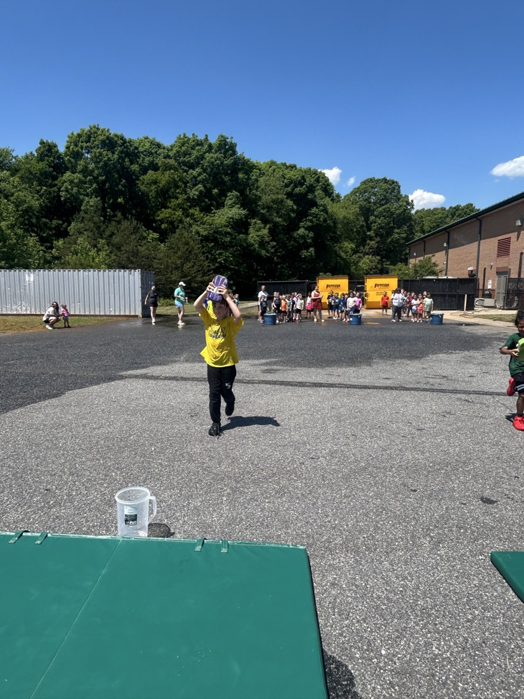 Child running with wet sponge toward bucket.