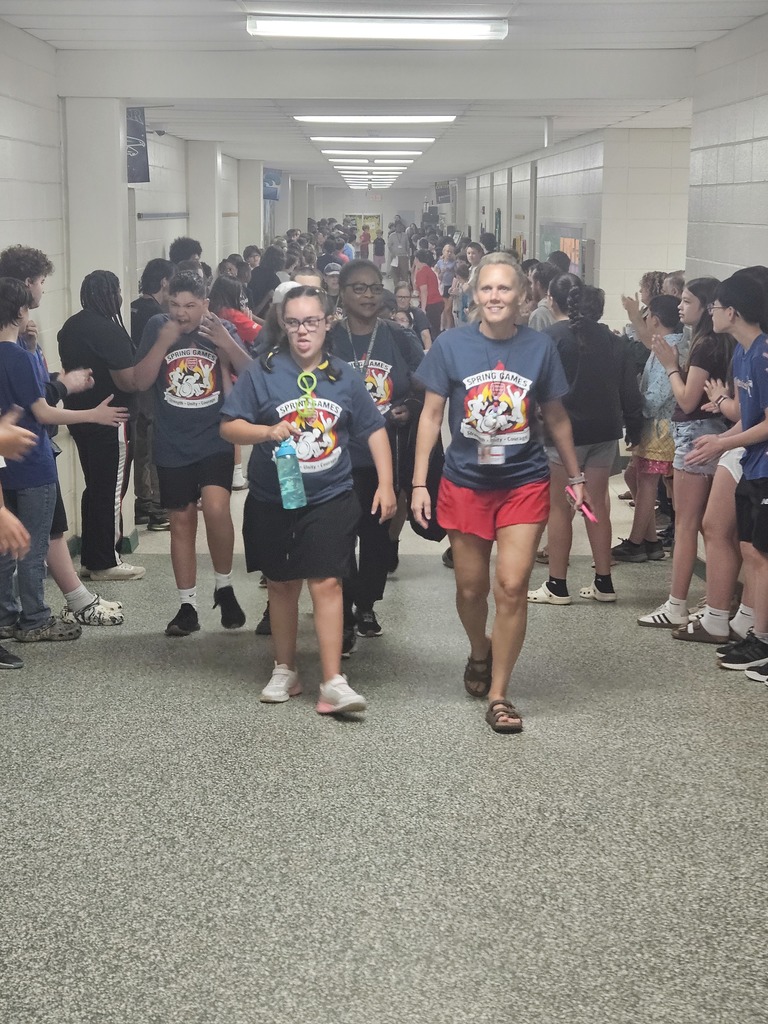 A crowd of students walking in a school hallway. One student is holding a water bottle.
