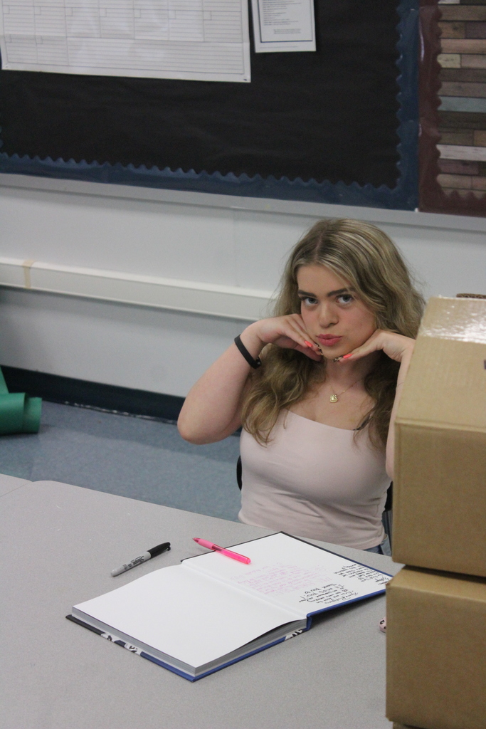 Yearbook students signing their yearbooks. 