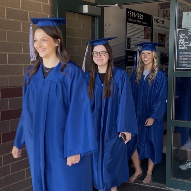 North Lincoln High School seniors coming out of front door of Rock Springs in graduation attire