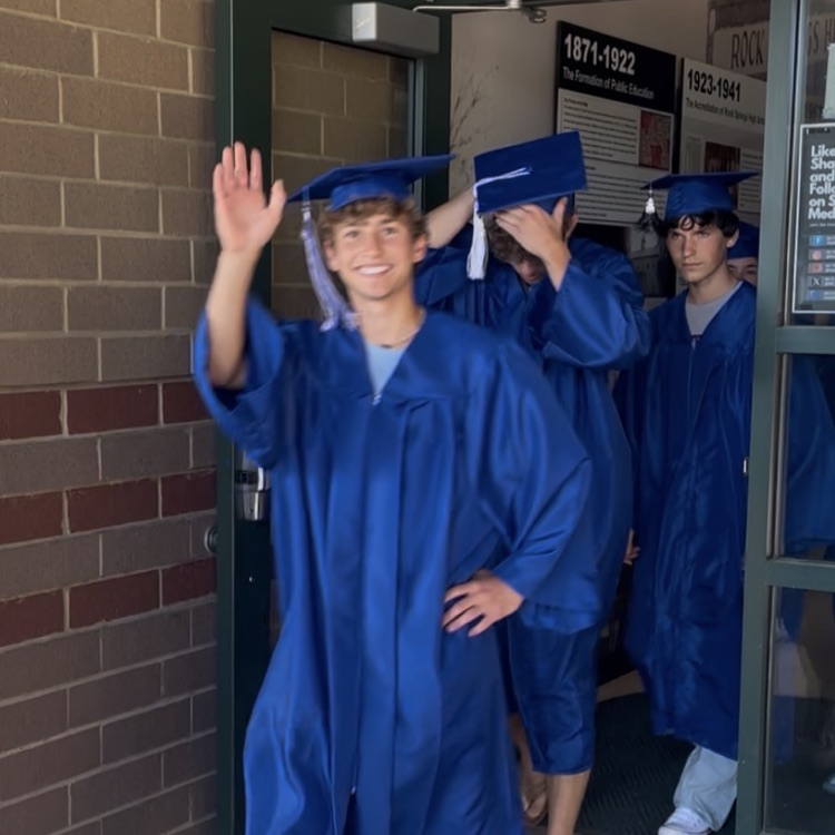 North Lincoln High School seniors coming out of front door of Rock Springs in graduation attire