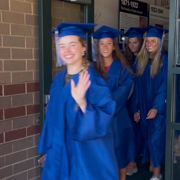 North Lincoln High School seniors coming out of front door of Rock Springs in graduation attire